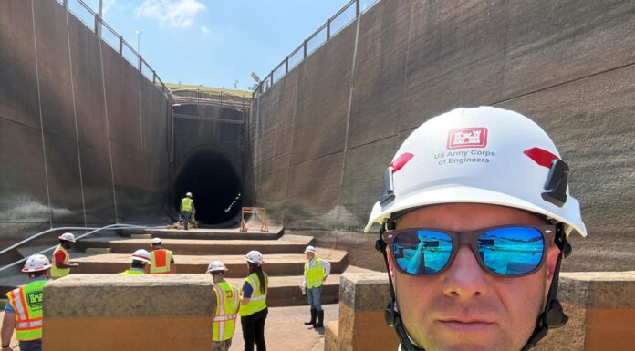 Alumnus supports water projects as district deputy for Corps of Engineers A group of workers in safety vests and helmets stand near a large tunnel under construction; one man is in the foreground.