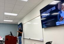 Mercer professor, students hold inaugural camp for teens in foster care A person stands at a podium in a classroom with a screen displaying Review and Accept Your Financial Aid.