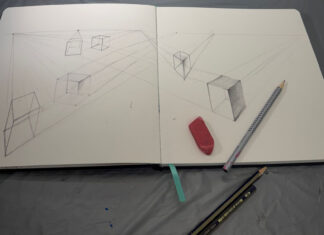 The perspective we choose makes all the difference | Craig McMahan, Ph.D. Open sketchbook with perspective cube drawings, an eraser, and two pencils on a gray surface.
