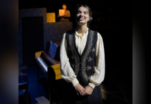 Mercer Theatre play honors female astronomy pioneers Young woman in vintage clothing stands in front of a piano on stage; another person reads from paper in the background.