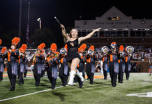 3 things to know about Mercer vs. The Citadel football game day: Oct. 31, 2026 A baton twirler leaps in front of a marching band on a football field at night.