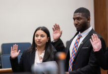 From adoptee to advocate: Law student honored for commitment to access to justice A woman and a man in professional attire stand with their right hands raised to take an oath.