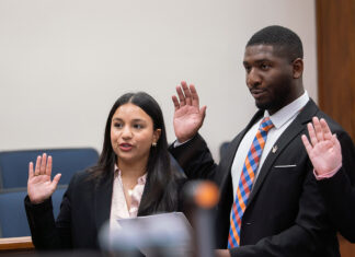 From adoptee to advocate: Law student honored for commitment to access to justice A woman and a man in professional attire stand with their right hands raised to take an oath.