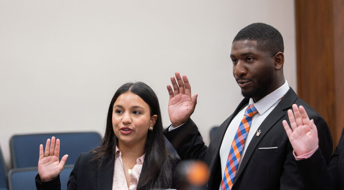 From adoptee to advocate: Law student honored for commitment to access to justice A woman and a man in professional attire stand with their right hands raised to take an oath.