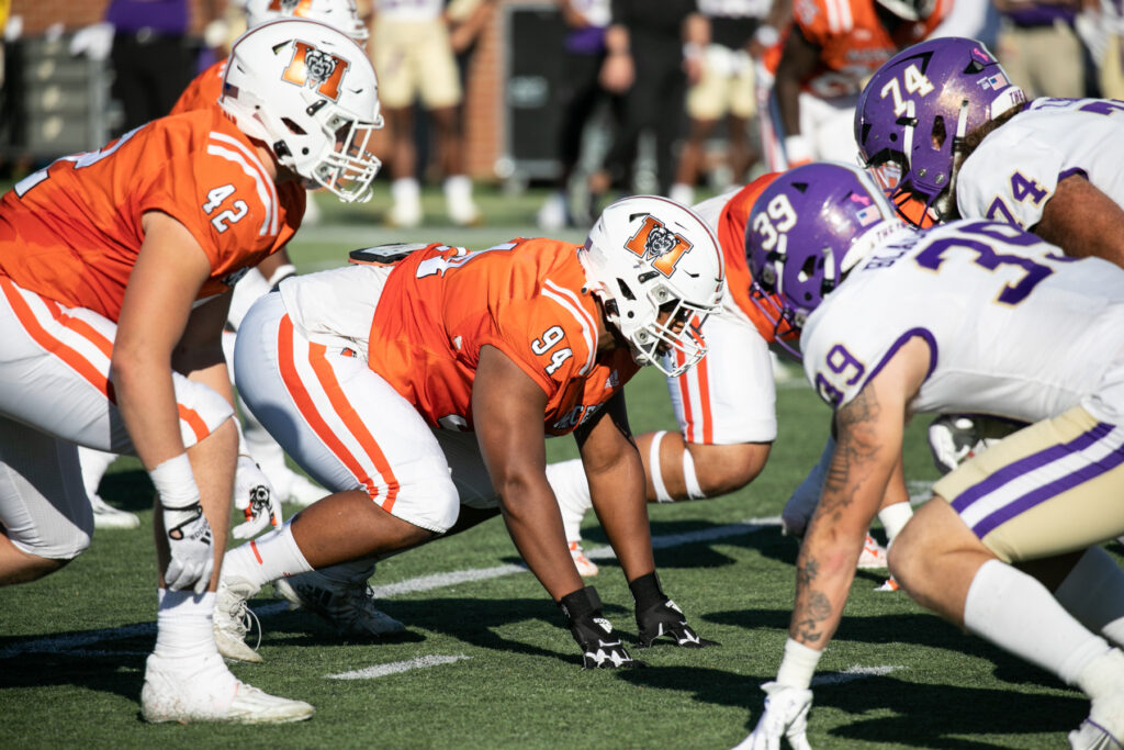 Mercer and Western Carolina football players face each other at the line of scrimmage.