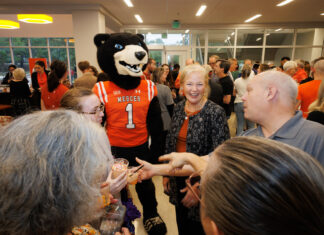 Countdown to 19 continues with University-wide, community events A Mercer University bear mascot stands in a crowded room with people, including the Mercer president, holding small ice cream cups.
