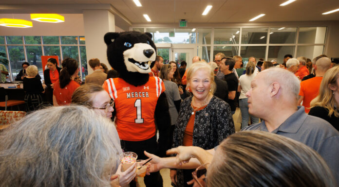 Countdown to 19 continues with University-wide, community events A Mercer University bear mascot stands in a crowded room with people, including the Mercer president, holding small ice cream cups.