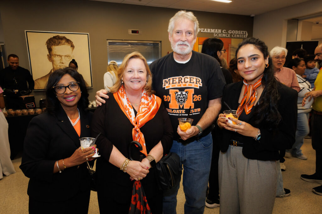 Four people standing together at an ice cream social.