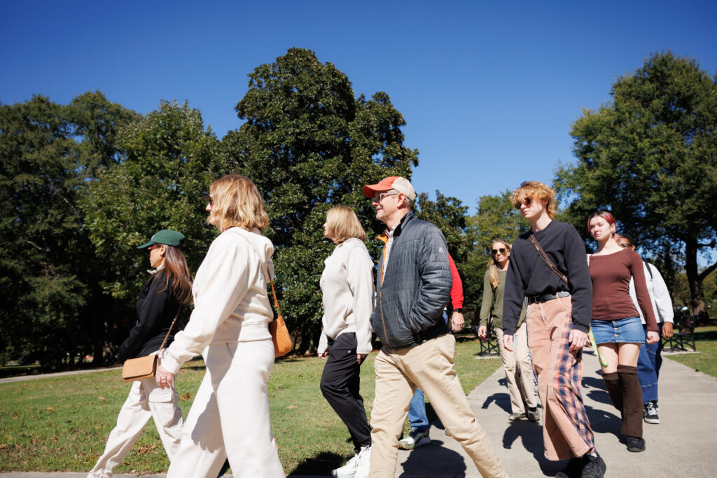 A group of people walking together on a paved path in a park.