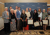11th annual alumni awards recognize outstanding Mercerians Group of ten people standing in front of a Mercer University backdrop, holding awards and certificates.