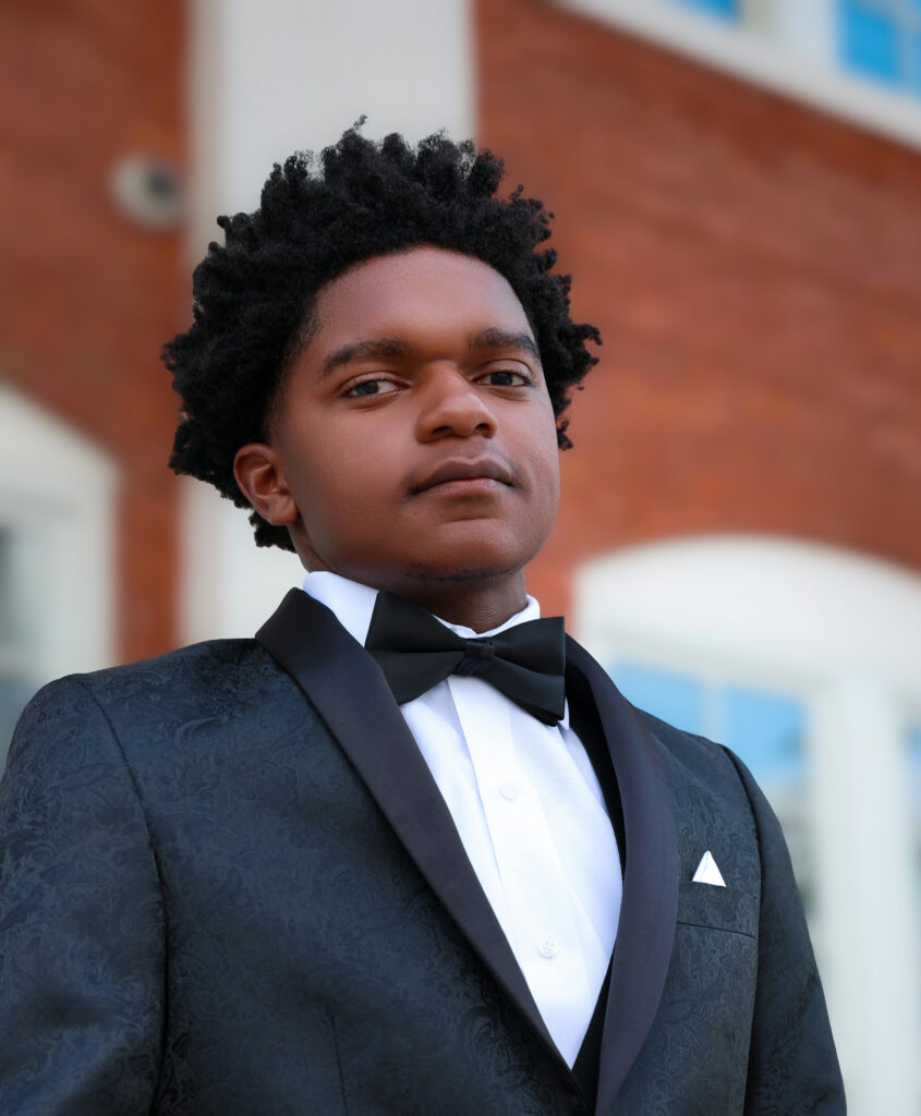 A young man in a tuxedo with a black bowtie.