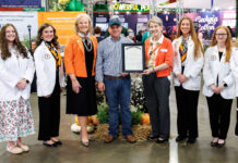 Georgia Agriculture Commissioner declares Mercer School of Medicine the State’s Official Georgia Grown Medical School Group of seven people posing for a photo, with one person holding a framed certificate at an agricultural trade show.