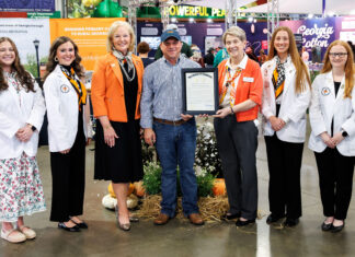 Georgia Agriculture Commissioner declares Mercer School of Medicine the State’s Official Georgia Grown Medical School Group of seven people posing for a photo, with one person holding a framed certificate at an agricultural trade show.