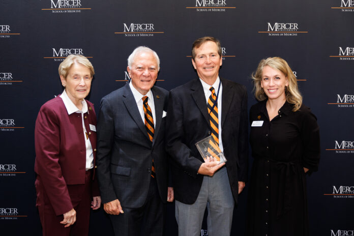 Mercer School of Medicine Dean Jean Sumner, M.D.; former Gov. Nathan Deal; Ed Grimsley, M.D.; and Mercer Vice President of External Relations Ember Bentley standing in front of a Mercer University School of Medicine backdrop.