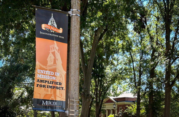 A banner on a pole reading One Mercer Inauguration 2026: United in Mission. Amplified for Impact.