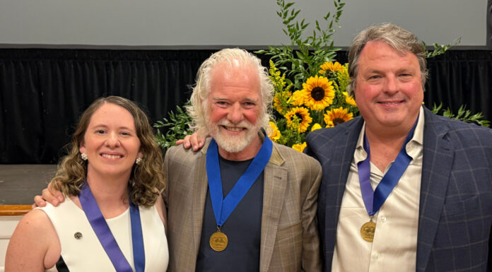 Mercerians honored with Cultural Arts Awards from Macon Arts Alliance Three people wearing blue ribbons with gold medals pose for a photo in front of a sunflower arrangement.