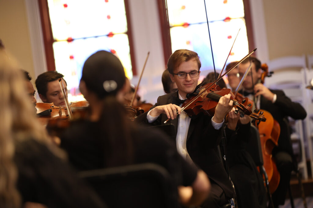 A violinist performing in an orchestra.