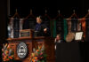 Penny L. Elkins, Ph.D. installed as 19th Mercer University president President Elkins in academic regalia speaks from a wooden podium at a university ceremony.