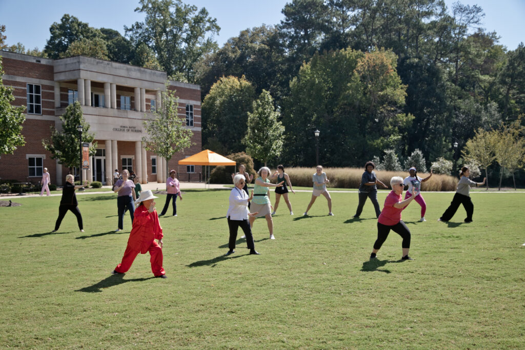 A group of people practicing tai chi on the Upper Quad of Mercer's Atlanta campus.